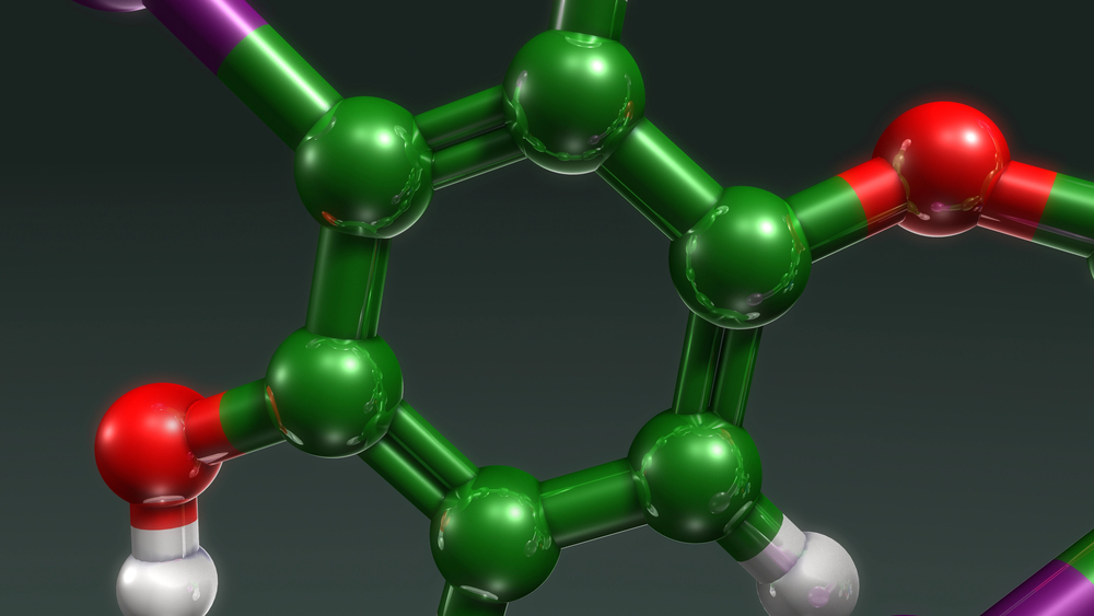 3D molecular model of a benzene ring with green carbon, red oxygen, white hydrogen, and purple atoms